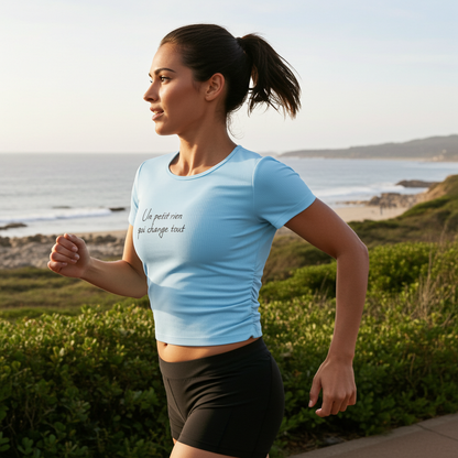 Femme faisant du jogging en bord de mer portant un t-shirt sport bleu ciel avec message inspirant 'Un petit rien qui change tout' - M|A PERSPECTIVE